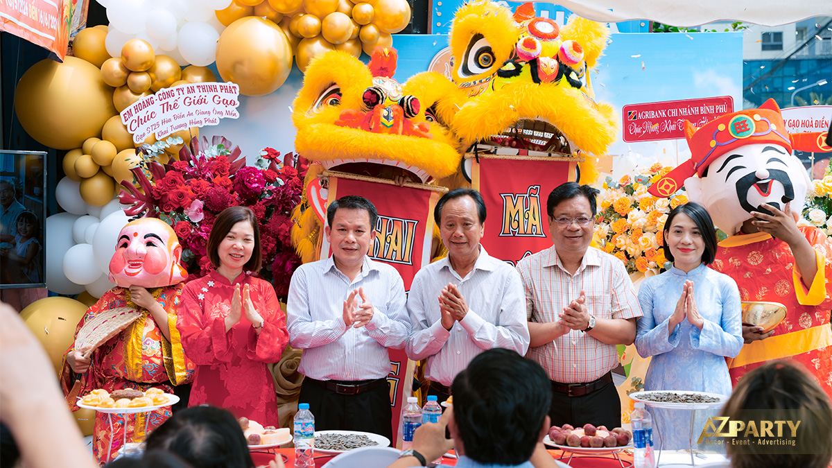 Chủ cửa hàng Thế Giới Gạo cùng khách mời và đối tác chụp ảnh lưu niệm bên đội múa lân và ông địa