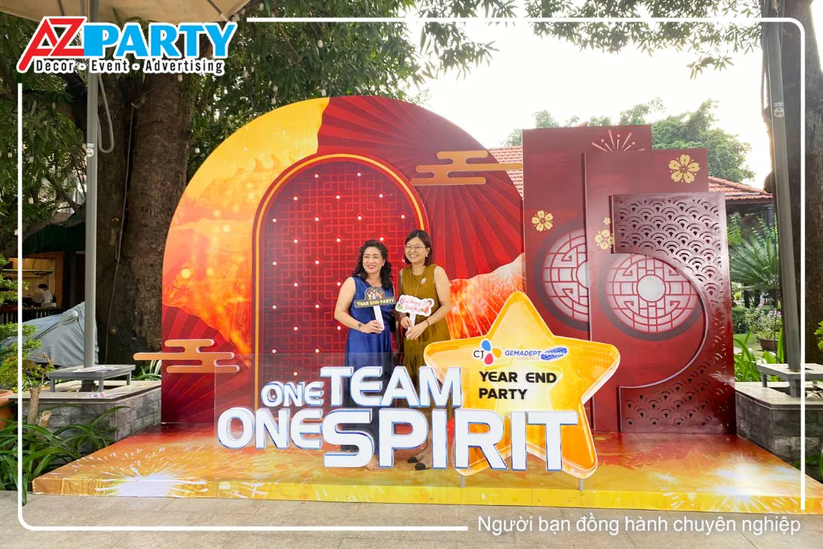 Khách tham dự chụp ảnh lưu niệm tại booth check-in ngoài trời của sự kiện Year End Party CJ Gemadept Logistics, được thiết kế theo chủ đề One Team One Spirit.