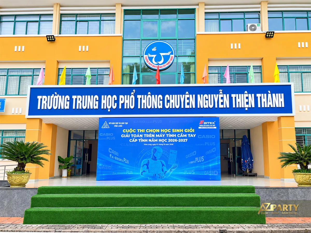 Backdrop cuộc thi đặt trước sảnh Trường THPT chuyên Nguyễn Thiện Thành và bậc thềm xanh