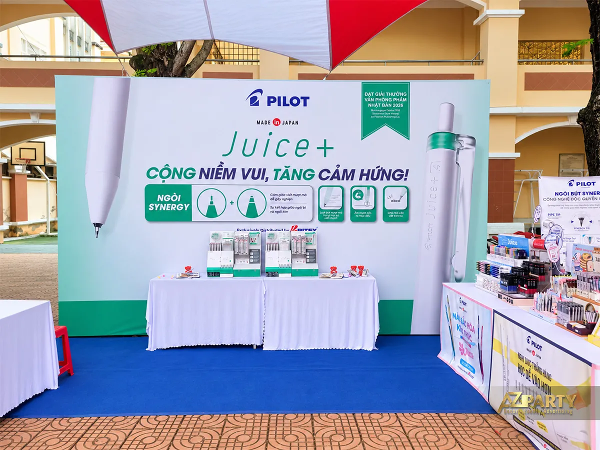 Vách PILOT Juice+ xanh trắng phía sau bàn trưng bày bút trong khuôn viên trường