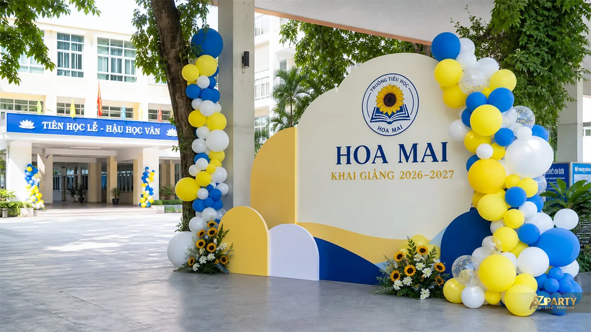 Backdrop khai giảng Hoa Mai màu vàng xanh trắng đặt dưới tán cây sân trường