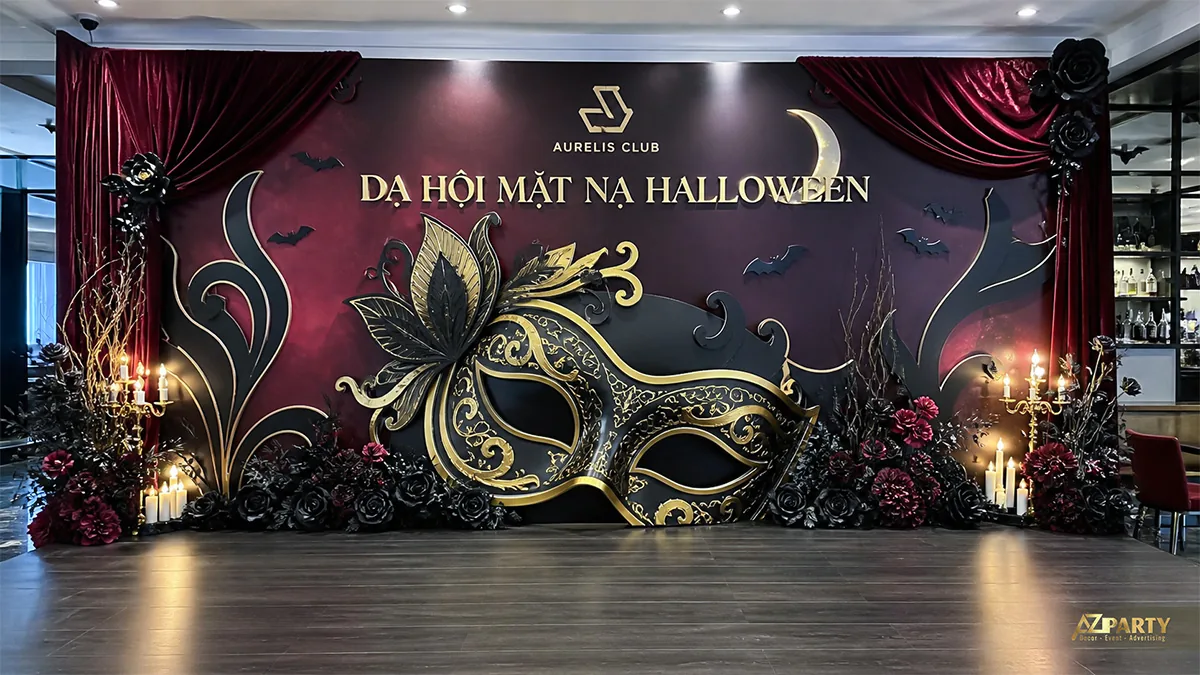 Khu check-in dạ hội mặt nạ Halloween với mặt nạ đen vàng, rèm nhung và nến
