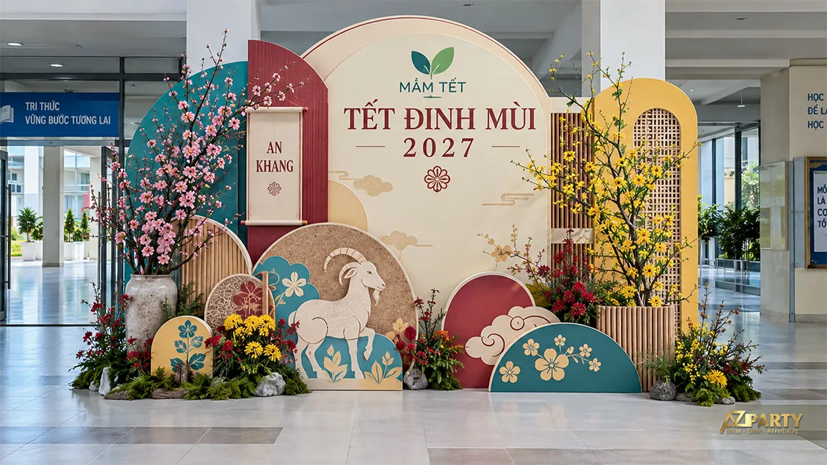 Backdrop tông kem xanh đỏ với mô hình dê, vách lưới và chậu hoa ở sảnh trường