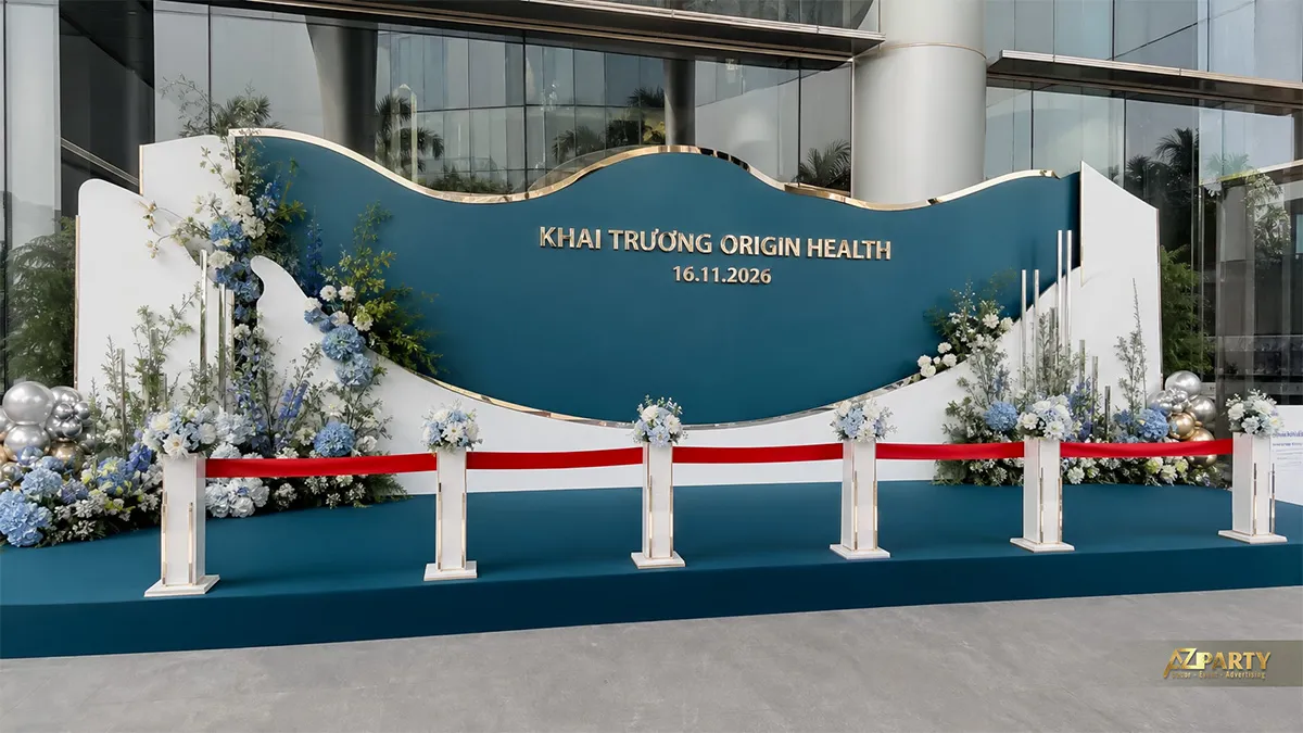Backdrop Origin Health xanh teal dáng sóng với hoa xanh trắng và bóng bạc