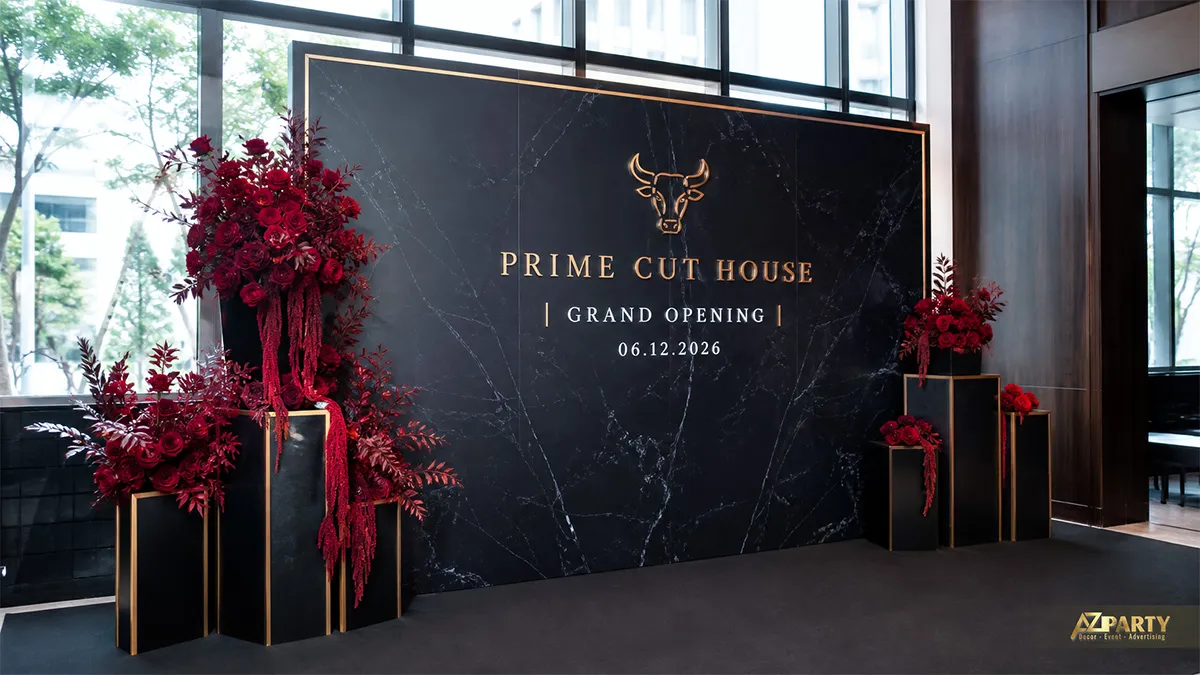 Backdrop Prime Cut House nền đen vân đá với logo đầu bò vàng và hoa đỏ