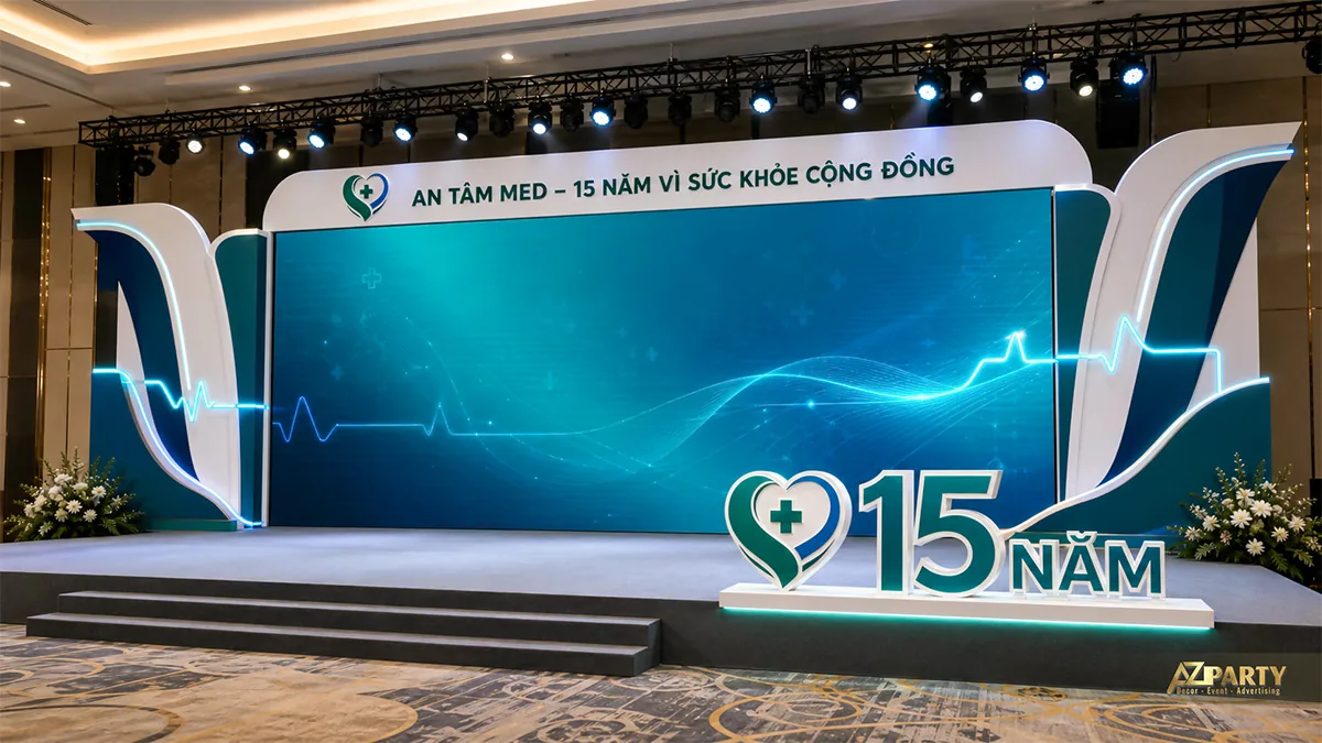 Backdrop sân khấu 15 năm An Tâm Med phối xanh ngọc và nhịp tim phát sáng