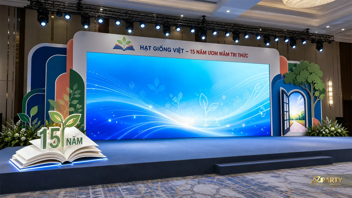 Backdrop 15 năm Hạt Giống Việt với cuốn sách mở và mảng cây xanh