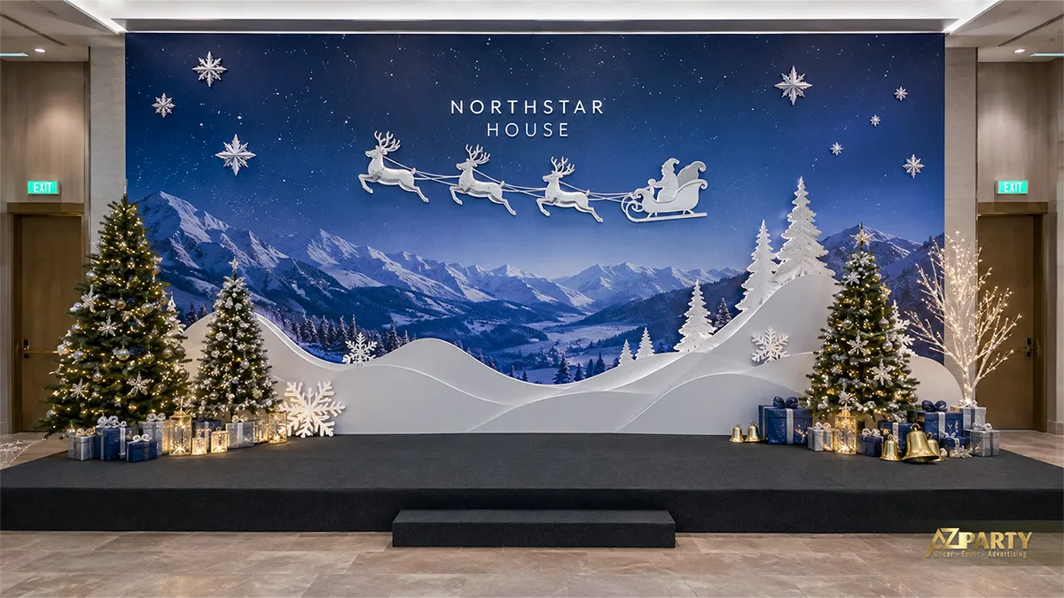 Backdrop Noel nền xanh đêm với dãy núi tuyết, xe trượt tuyết và hai cụm cây thông trên sân khấu