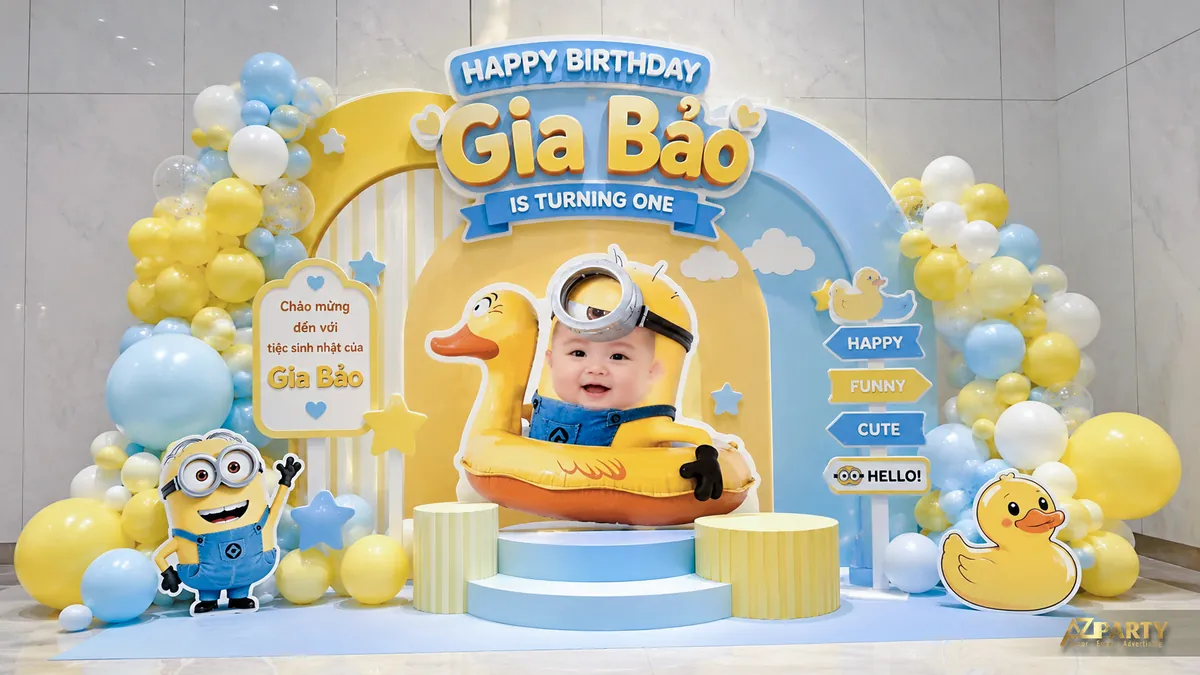 Backdrop sinh nhật Minions xanh vàng với vịt con, cụm bóng pastel và ảnh bé ở trung tâm