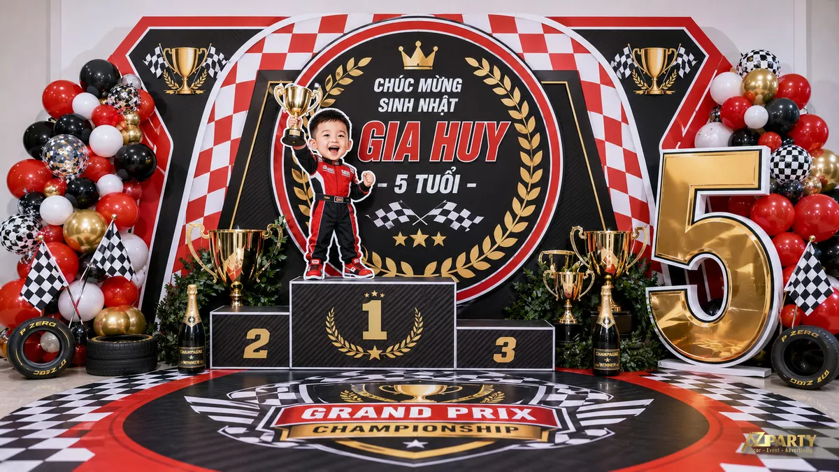 Phông sinh nhật xe đua Grand Prix đỏ đen cho bé Gia Huy 5 tuổi với cúp vàng và podium chiến thắng
