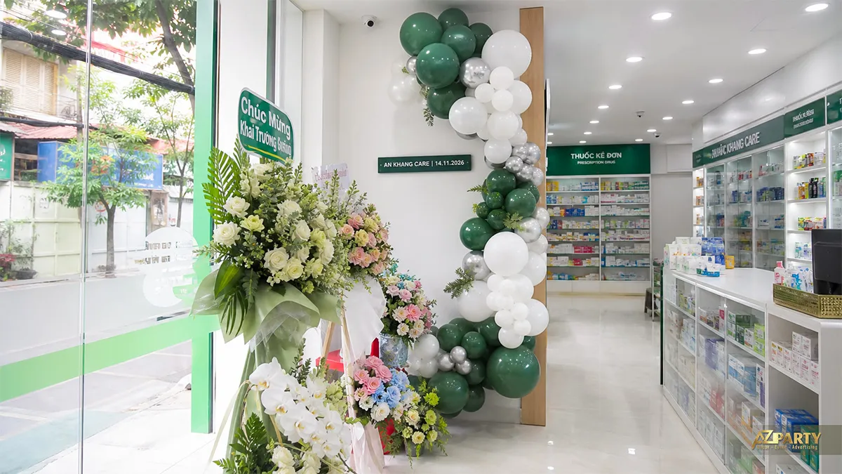 Lối vào nhà thuốc An Khang Care với trụ bóng xanh đậm, trắng, bạc và các kệ dược phẩm