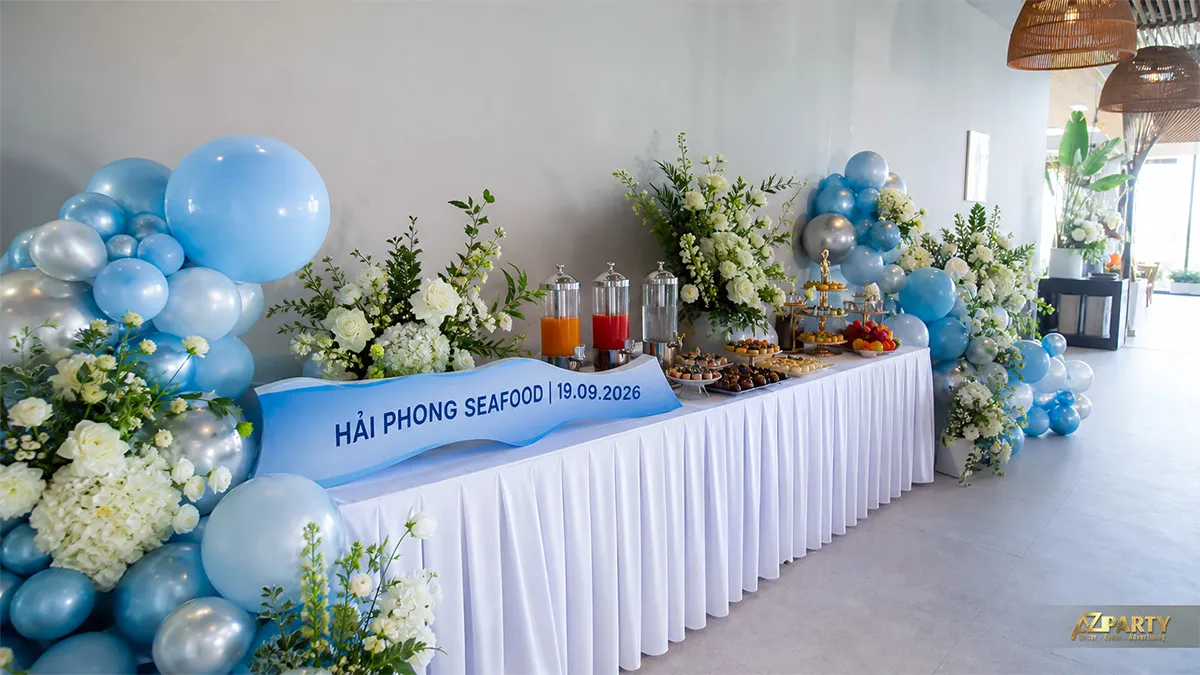 Bàn tiệc Hải Phong Seafood trang trí bóng xanh dương, bạc và các cụm hoa trắng