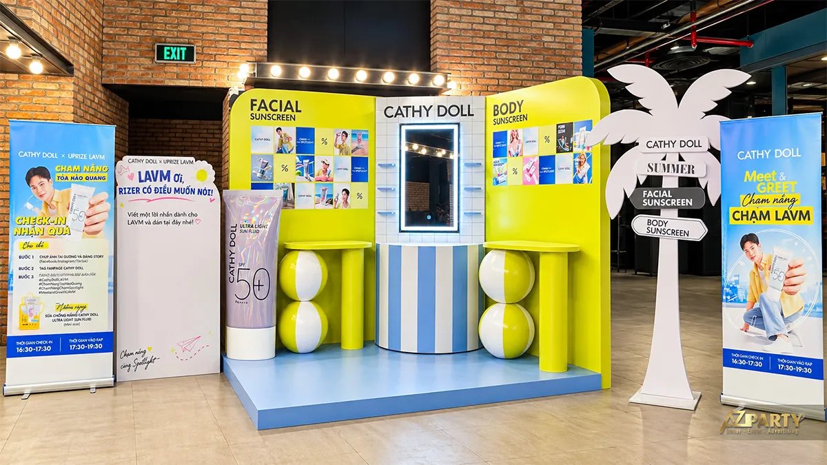 Toàn cảnh booth Cathy Doll với vách vàng, gương sáng ở giữa và khu giới thiệu chương trình hai bên