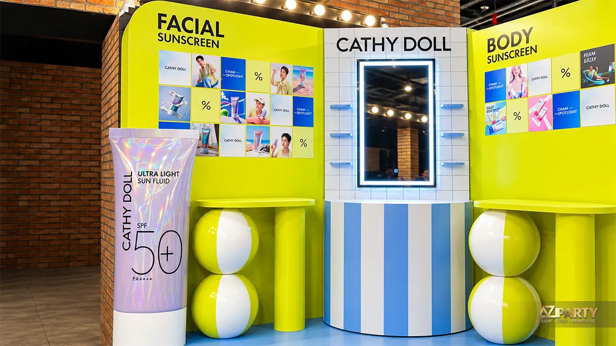 Mô hình tuýp kem chống nắng Cathy Doll SPF 50+ đặt cạnh quầy gương và vách hình sản phẩm