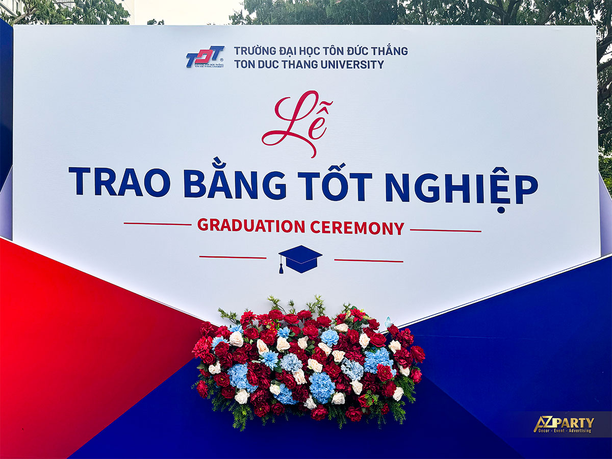Backdrop chính Lễ Trao Bằng Tốt Nghiệp Đại học Tôn Đức Thắng 2026 với hoa trang trí