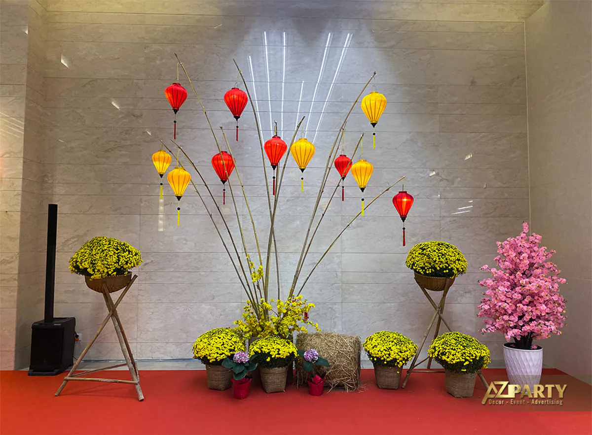 Tiểu cảnh trang trí mang đậm nét Tết xưa với các cành tre khô treo đèn lồng Hội An sắc đỏ vàng, kết hợp chậu cúc mâm xôi vàng rực.