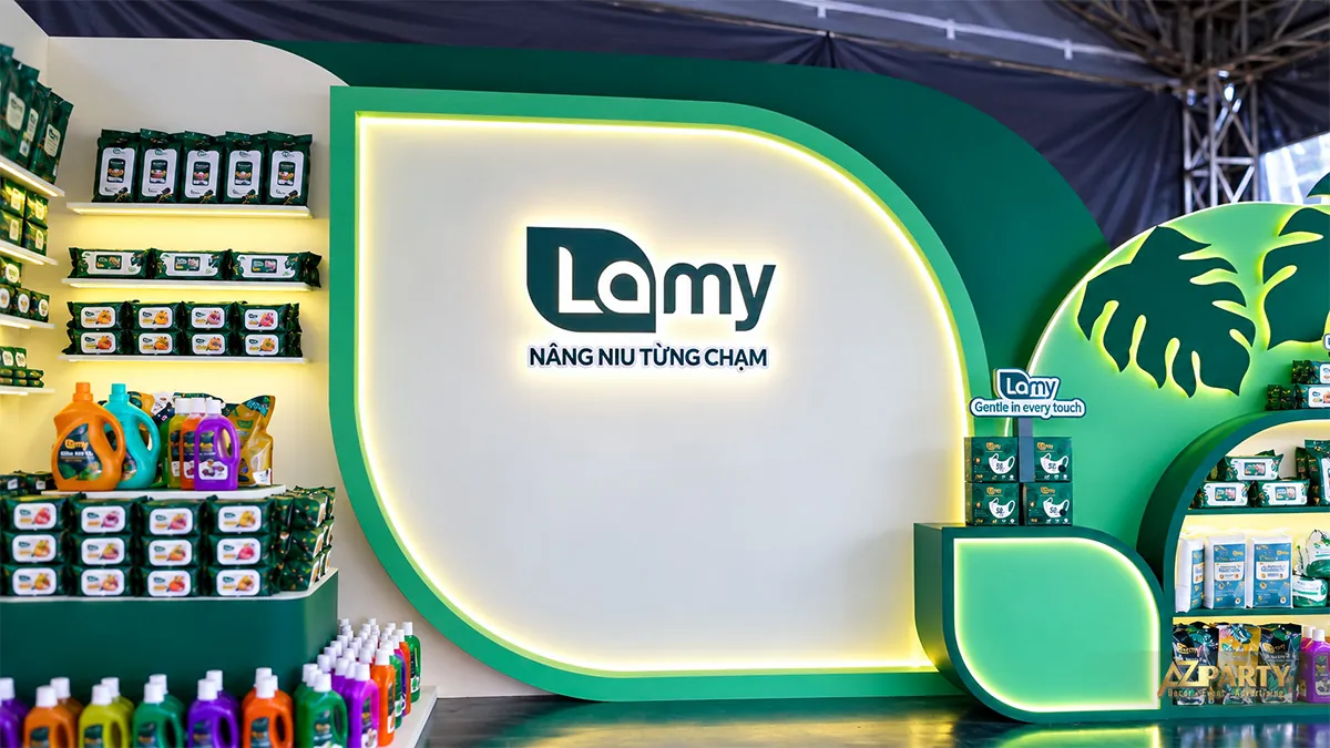 Cận cảnh logo Lamy trên vách trắng viền xanh sáng, cạnh các kệ sản phẩm