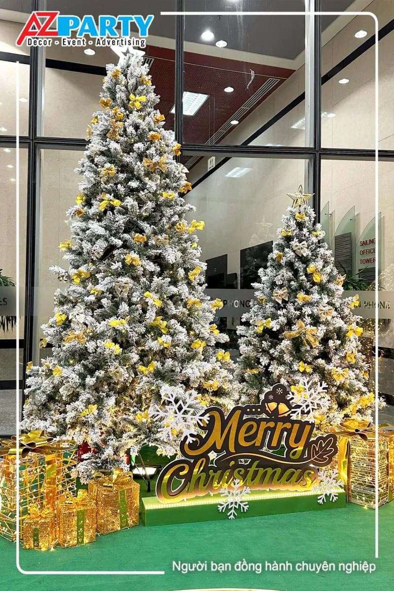 cây thông noel phủ tuyết trắng, trên ngọn có ngôi sao, thân cây có đính nơ vàng lấp lánh