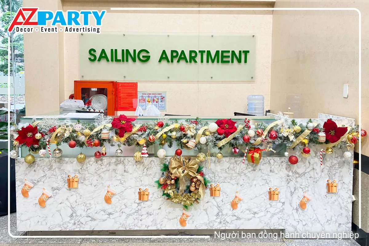 quầy lễ tân được trang trí với dây thông kèm theo các phụ kiện như quả châu, vòng nguyệt quế giáng sinh, hoa trạng nguyên