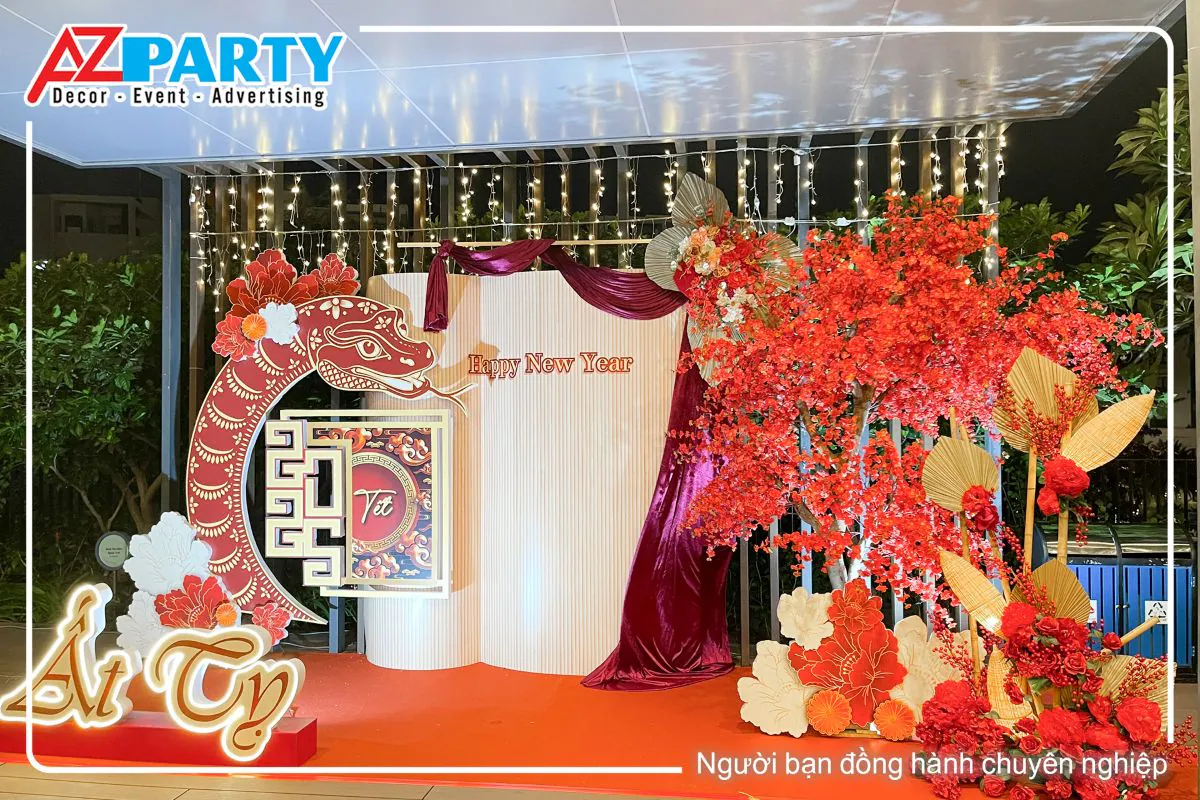 toàn cảnh tiểu cảnh tết Ất Tỵ tại chung cư One Verandah với tone mà đỏ đô. Bên phải của tiểu cảnh là cây đào đỏ rực, bên trái  là dòng chữ Ât Tỵ cùng chú rắn linh vật uốn cong, chính giữa là vách chính theo phong cách gấp khúc, có dòng chữ Happy New Year nổi bật