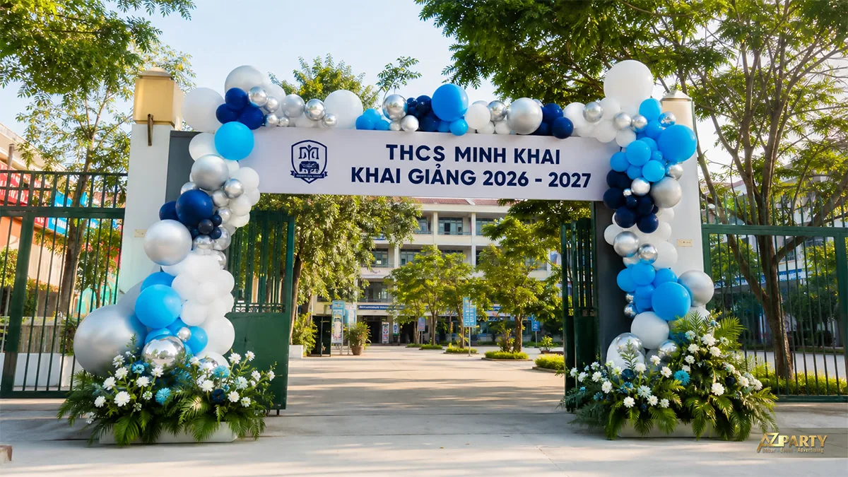 Cổng bóng xanh dương trắng bạc và hoa tươi tại cổng trường THCS
