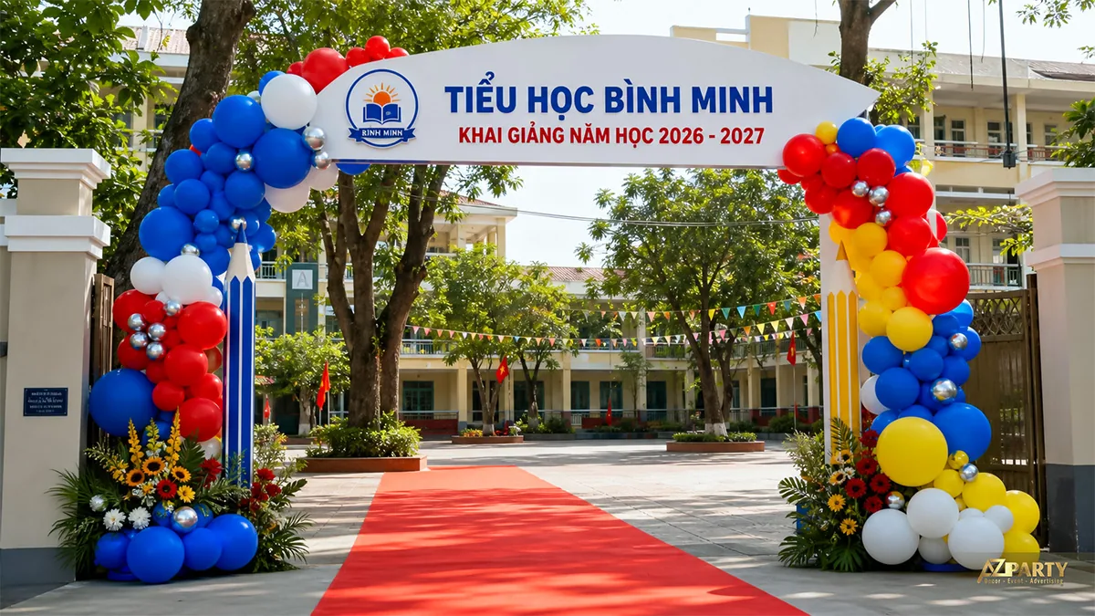 Cổng bóng khai giảng đỏ xanh vàng với mô hình bút chì và thảm đỏ tại trường tiểu học