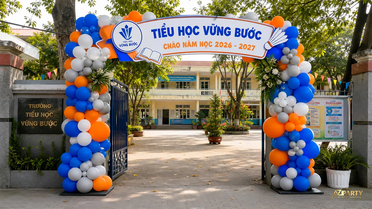 Cổng bóng xanh cam trắng với biểu tượng sách và cầu lông tại trường tiểu học