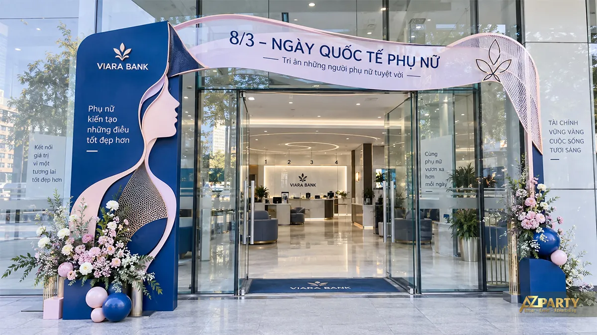 Cổng ngân hàng xanh navy, chân dung phụ nữ và dải hồng uốn trên đỉnh