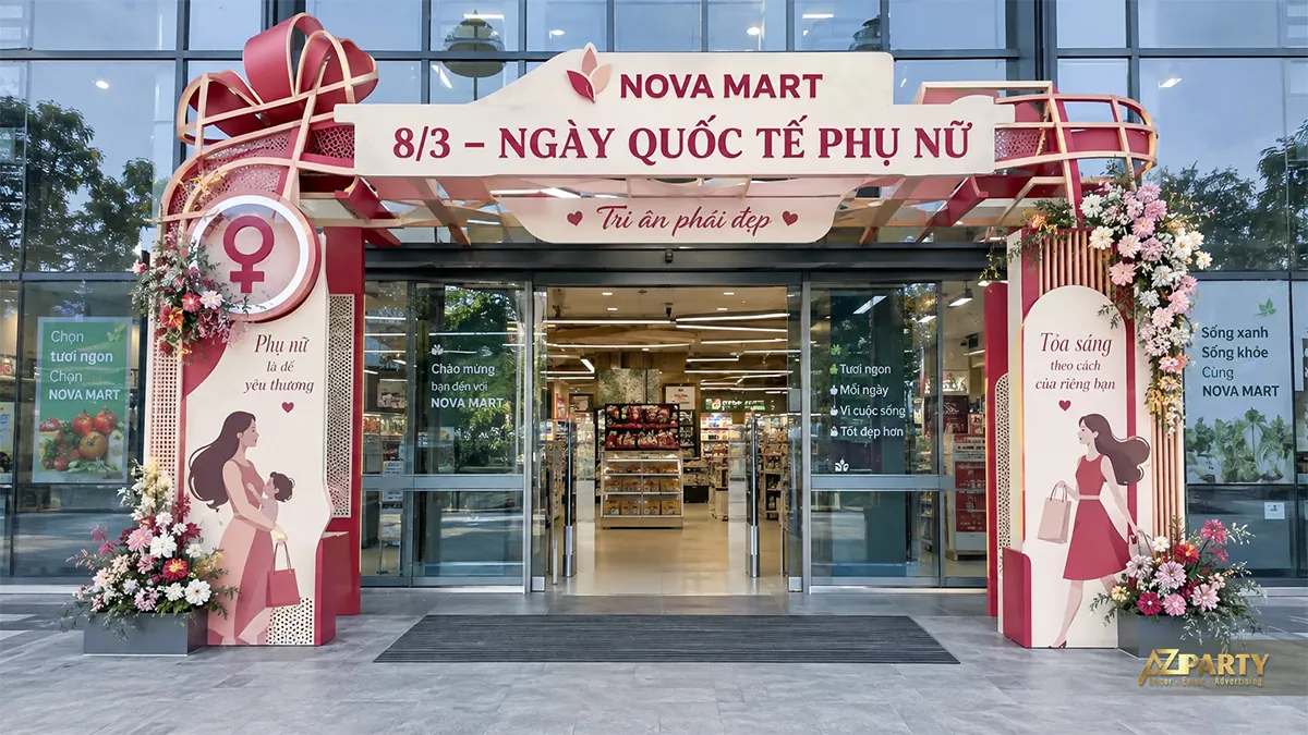 Cổng siêu thị đỏ kem với hình mẹ bế bé, người đi mua sắm và nơ