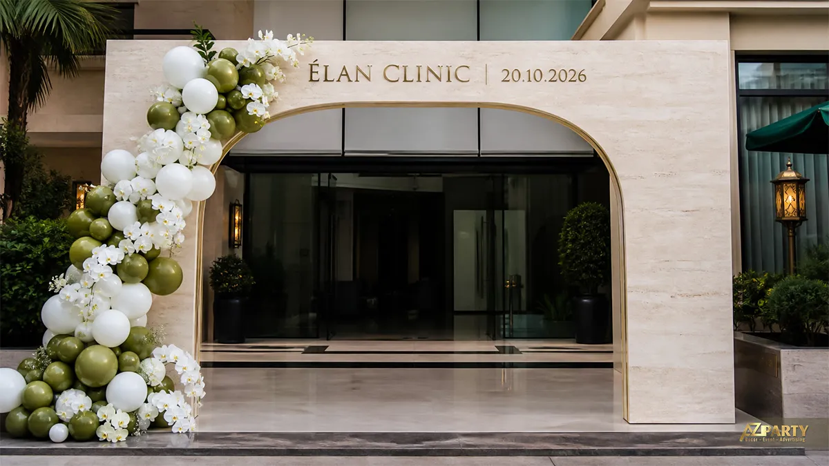 Cổng chào Élan Clinic vân đá dáng vòm với bóng xanh olive và lan trắng