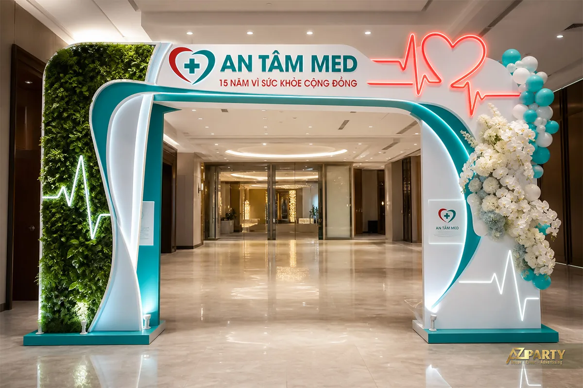 Cổng chào 15 năm An Tâm Med với vách cây xanh và nhịp tim đỏ