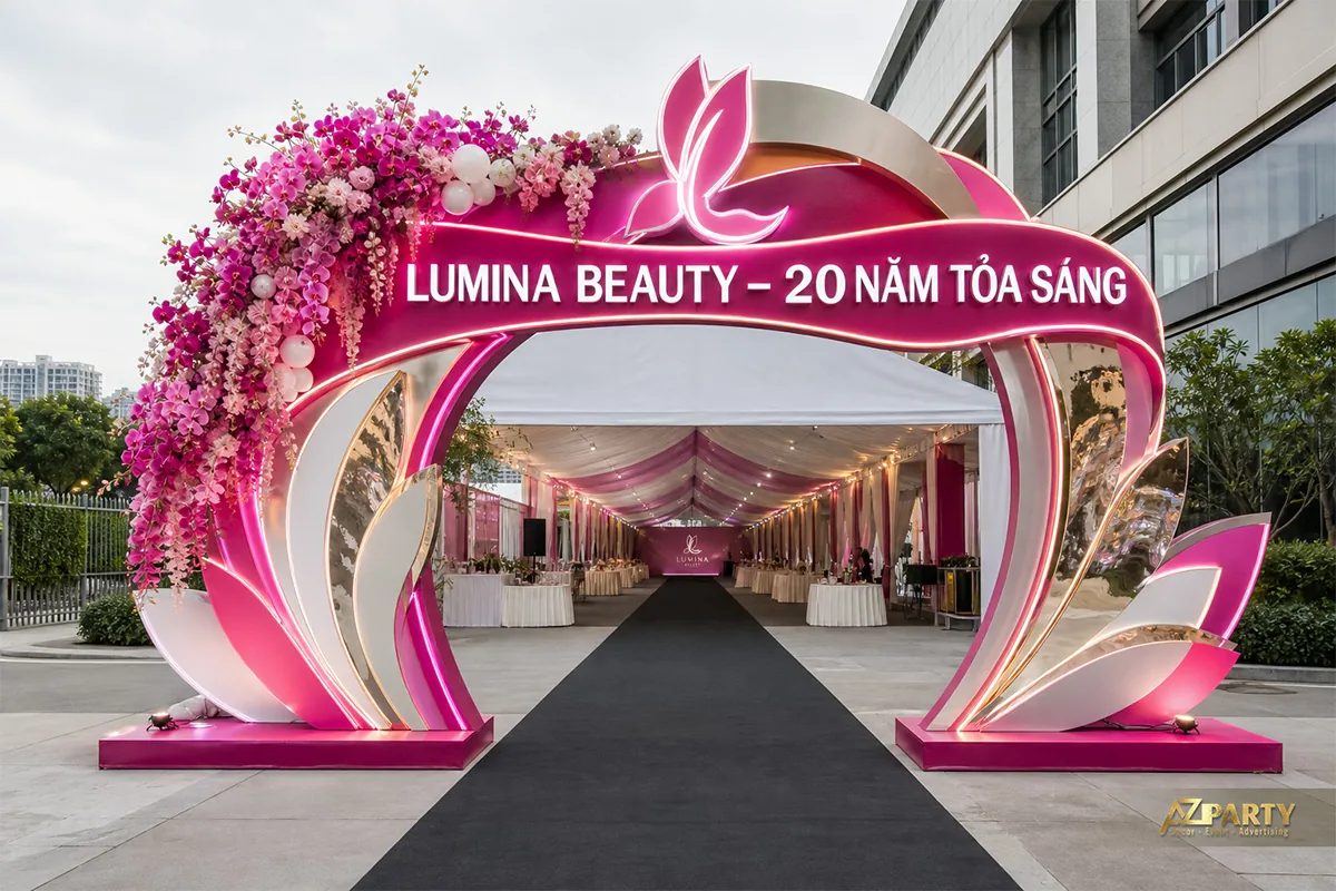 Cổng chào 20 năm Lumina Beauty màu hồng với hoa phủ một bên vòm