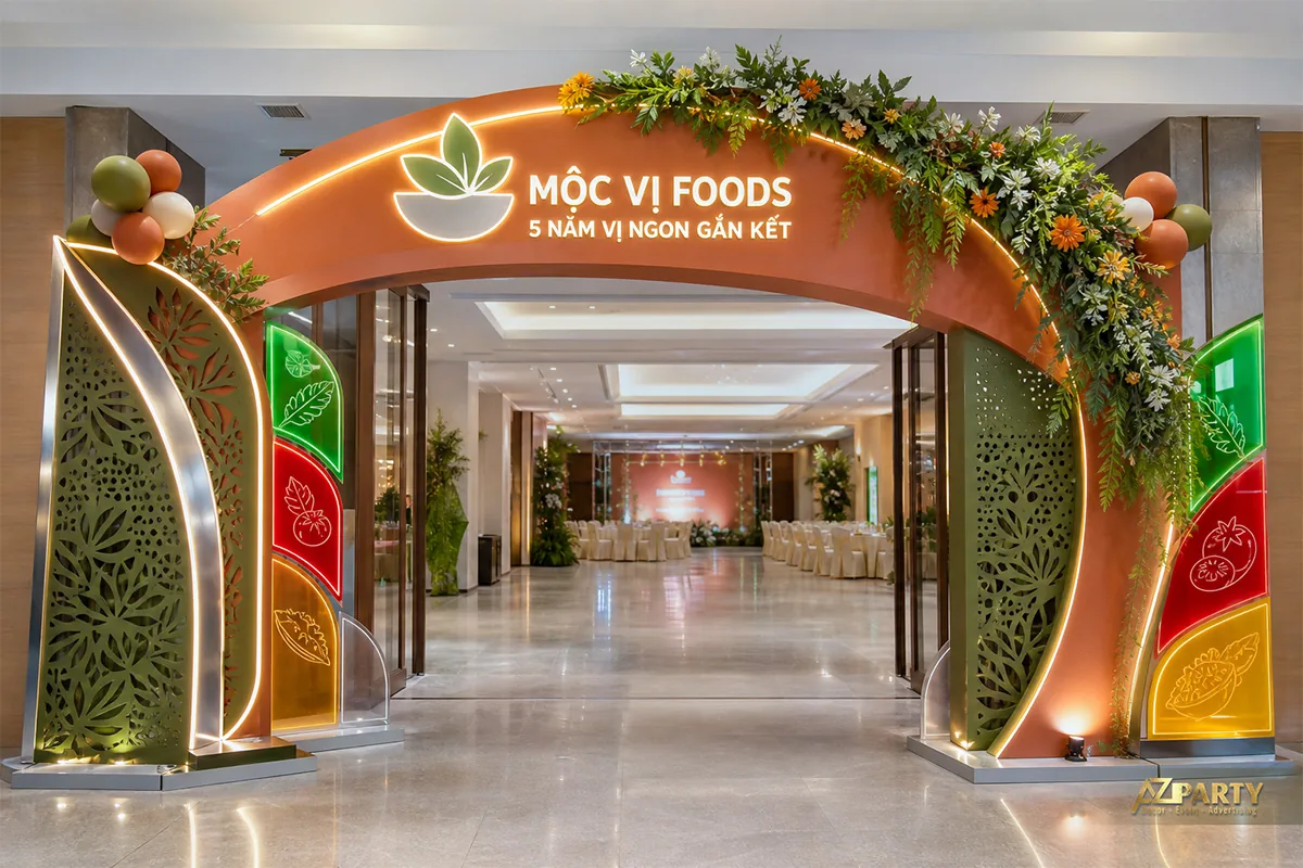 Cổng sự kiện 5 năm Mộc Vị Foods tông cam xanh với họa tiết lá