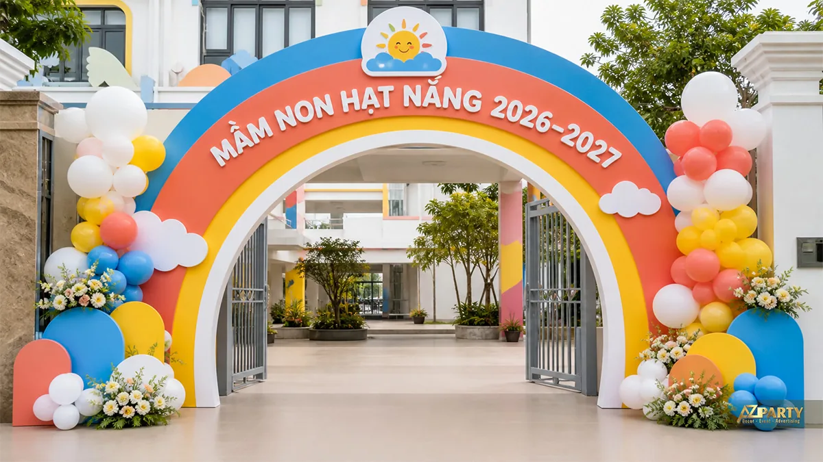 Cổng khai giảng mầm non Hạt Nắng hình cầu vồng với bóng và hoa hai bên
