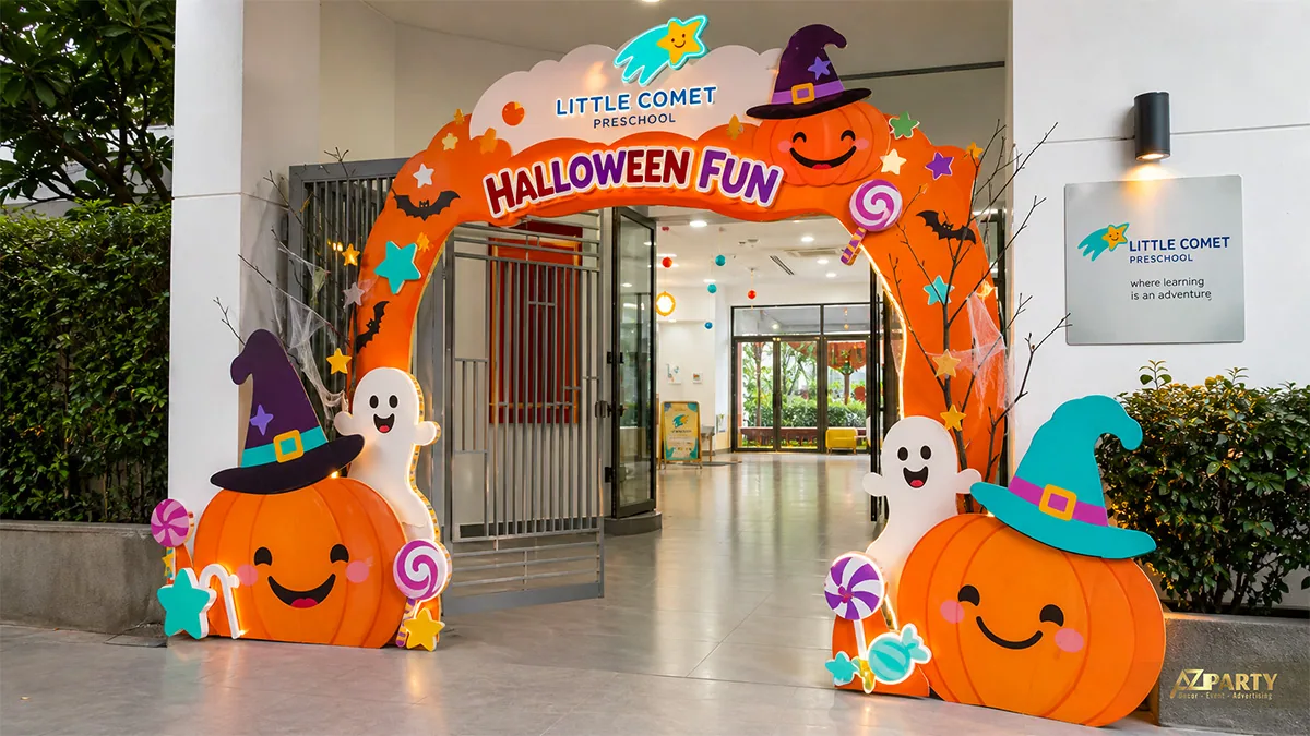 Cổng trường mầm non Halloween màu cam với bí ngô cười, ma nhỏ và kẹo