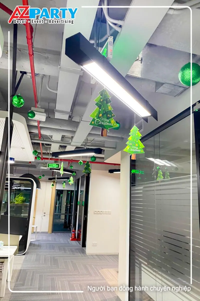 lối đi trong văn phòng có treo các quả châu xanh và cây thông noel mini