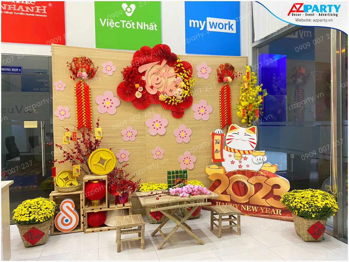 Trang trí tiểu cảnh Tết cổ truyền 2023 tại văn phòng với phông nền tre, mô hình mèo thần tài may mắn và chậu cúc mâm xôi vàng rực rỡ