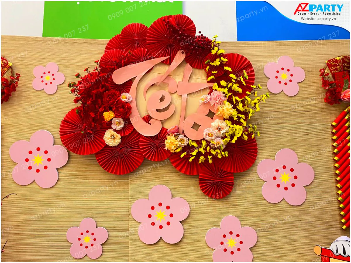 Cận cảnh cụm hoa mai vàng, hoa đào hồng và chữ Tết thư pháp cách điệu trang trí nổi bật trên phông nền cót tre truyền thống