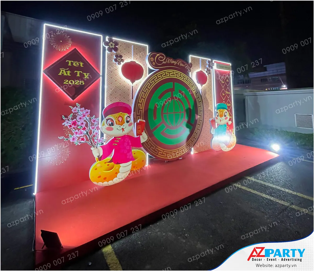 Góc nghiêng cận cảnh sân khấu trang trí Tết Ất Tỵ 2025 tại Takako Vietnam, thiết kế dạng 3D nổi bật với đèn neon viền và mô hình linh vật rắn mặc áo dài truyền thống