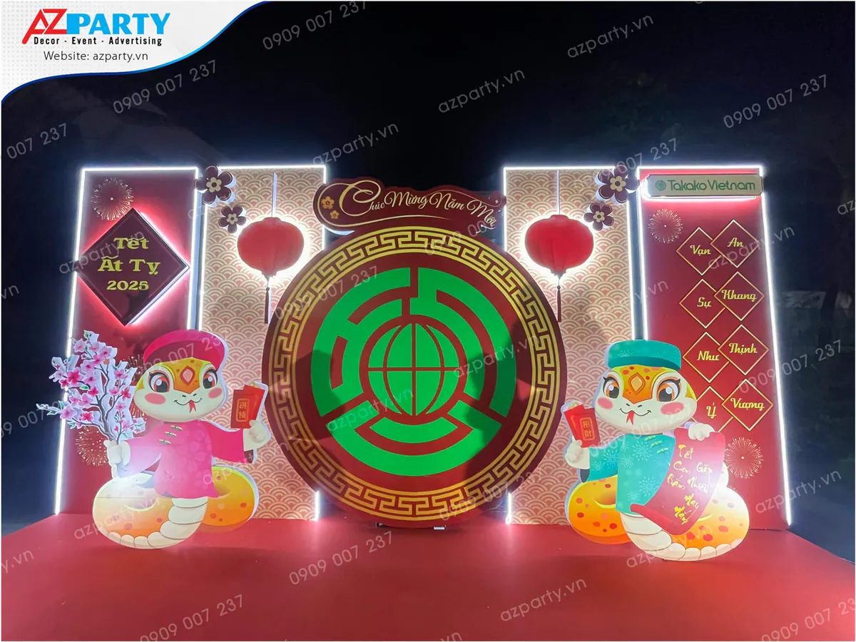 Cận cảnh backdrop trang trí Tết cổ truyền Ất Tỵ 2025 với hình ảnh linh vật rắn cách điệu đáng yêu, câu đối Tết chúc mừng năm mới cùng logo Takako Vietnam