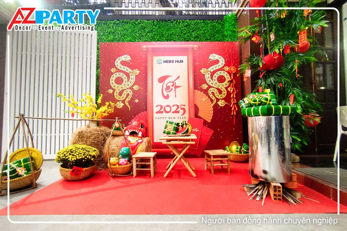 tiểu cảnh tết tại công ty Web 3 Hub, bên trái với đòn gánh bánh chưng bánh tét, bên phải là nồi bánh chưng xanh, chính giữa là bộ bàn ghế tre
