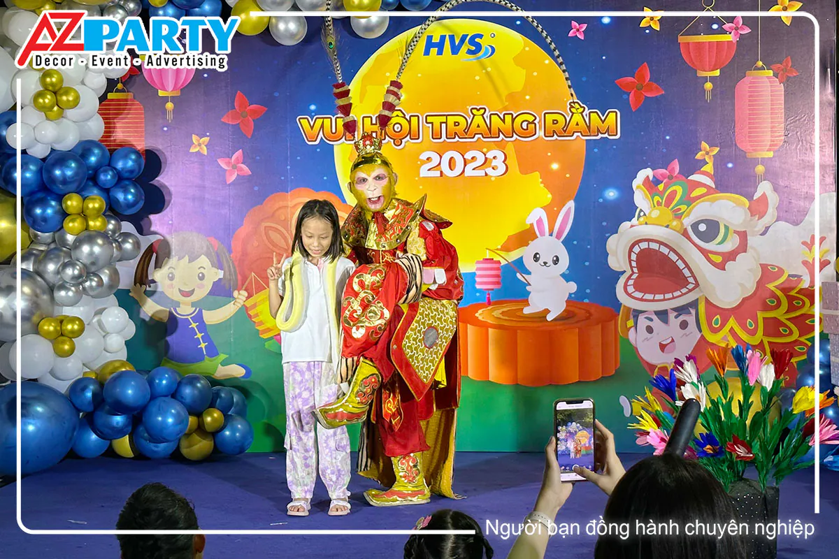 Tôn Ngộ Không chụp ảnh cùng bé gái trên sân khấu Vui Hội Trăng Rằm 2023 công ty HVS, phụ huynh chụp hình bằng điện thoại