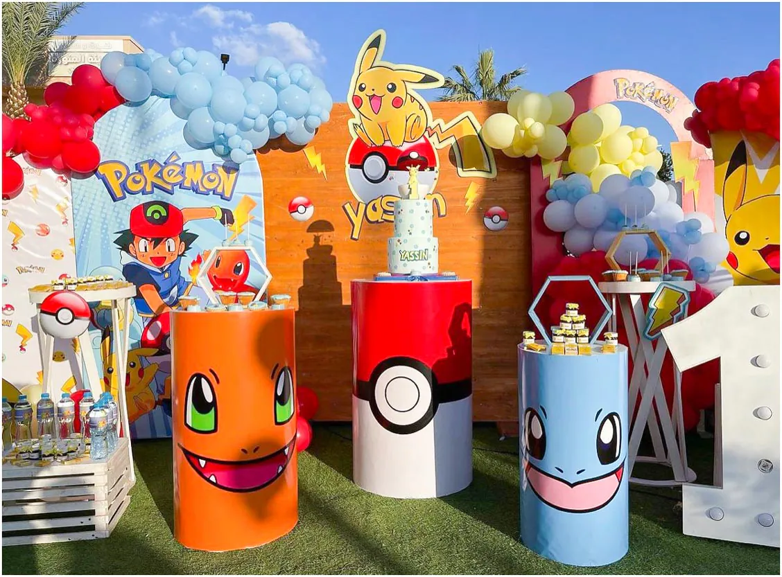 Trang trí tiệc sinh nhật ngoài trời chủ đề Pokemon cho bé Yassin với backdrop gỗ, các đôn tròn in hình gương mặt ngộ nghĩnh của các Pokemon như Charmander, Squirtle và bóng bay nhiều màu sắc rực rỡ.