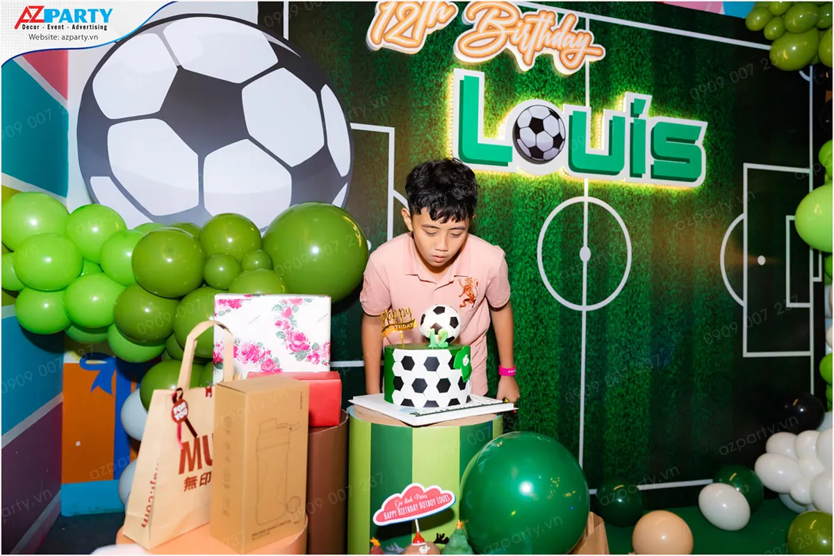 Bé Louis 12 tuổi rạng rỡ chuẩn bị thổi nến trên chiếc bánh sinh nhật tạo hình quả bóng đá 3D độc đáo.