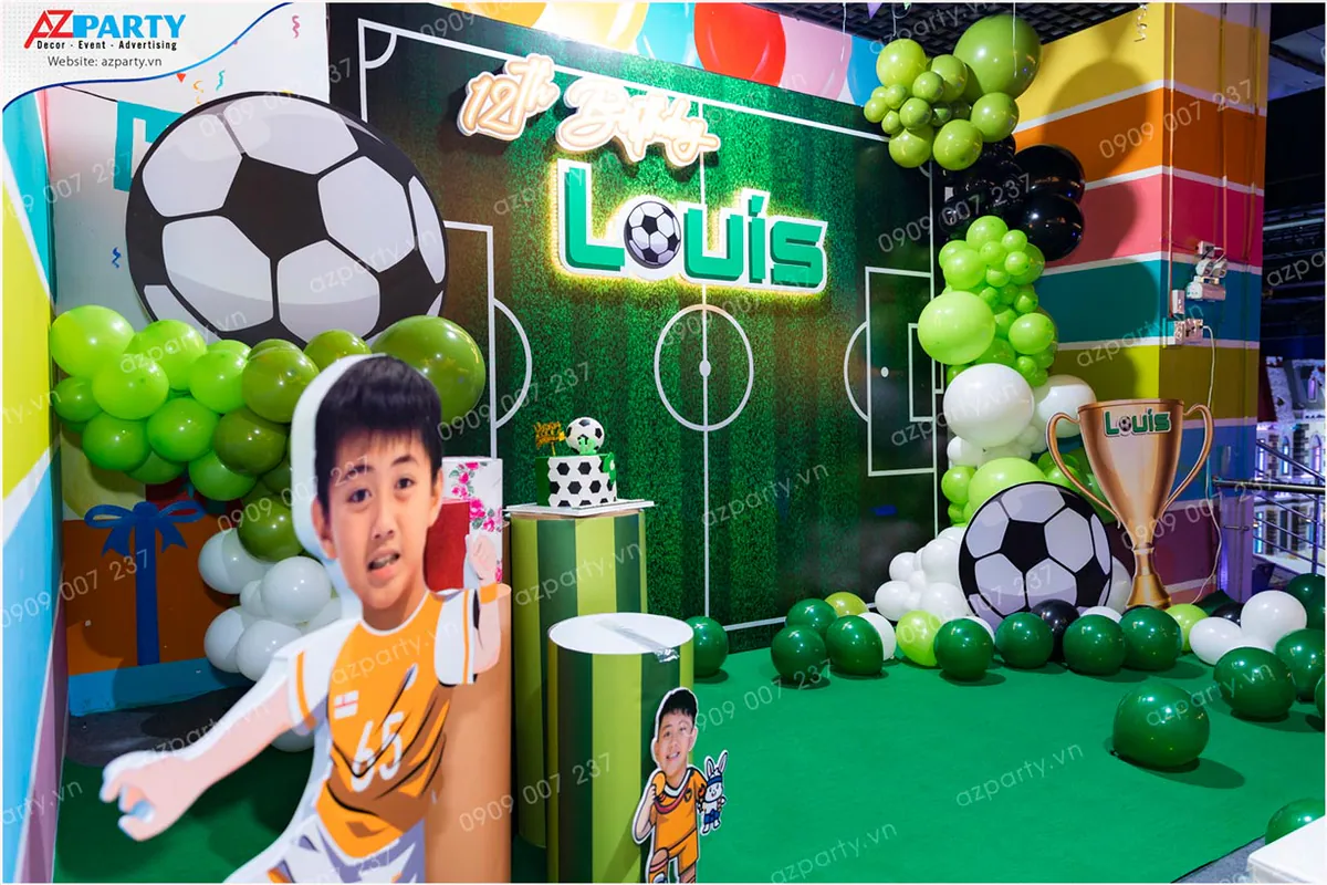 Bé Louis hạnh phúc chụp ảnh lưu niệm cùng gia đình thân yêu bên cạnh bàn gallery sinh nhật trang trí đẹp mắt.
