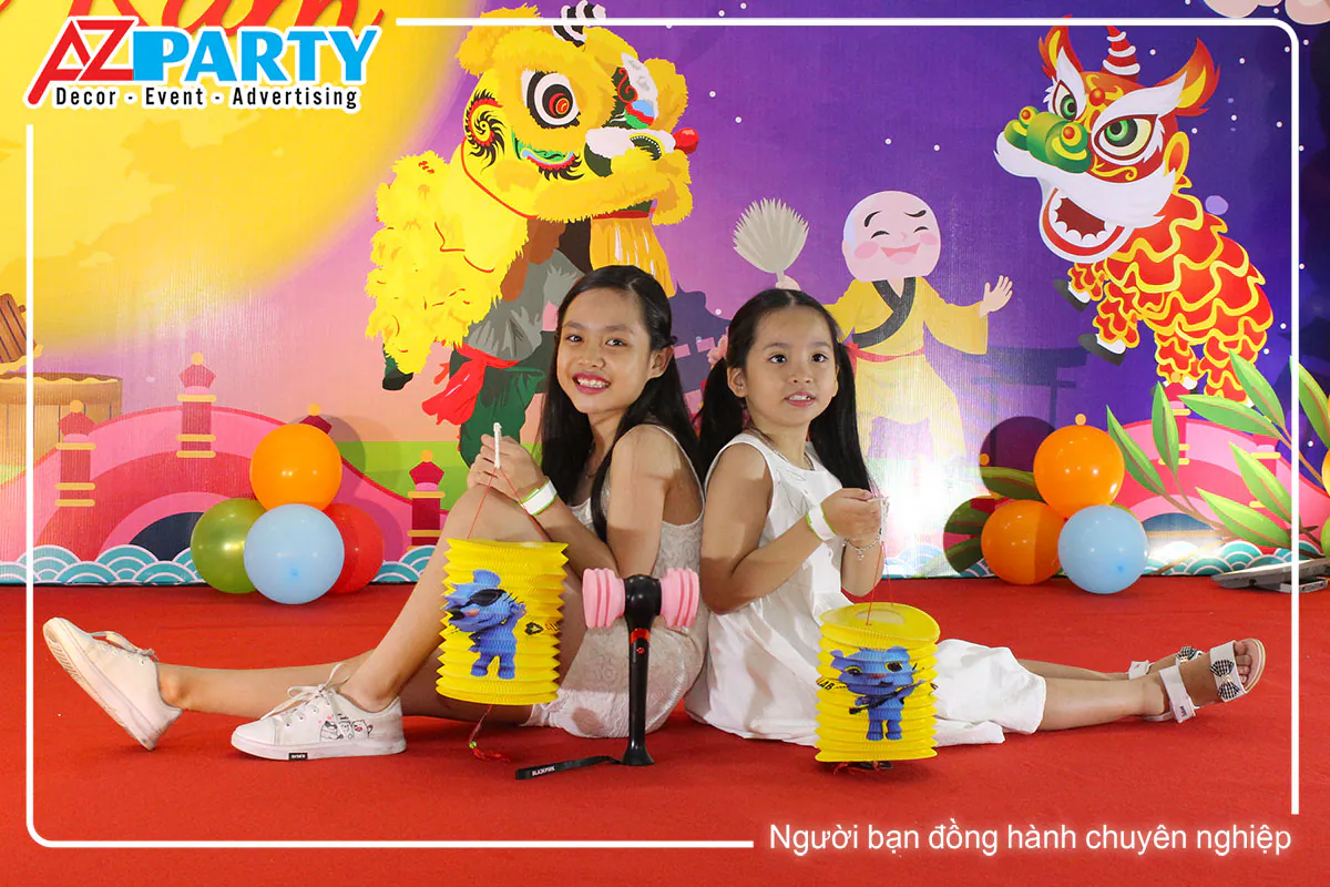Hai bạn nhỏ mặc trang phục áo dài truyền thống cầm lồng đèn chụp hình tại sân khấu Cộng Hòa Garden.