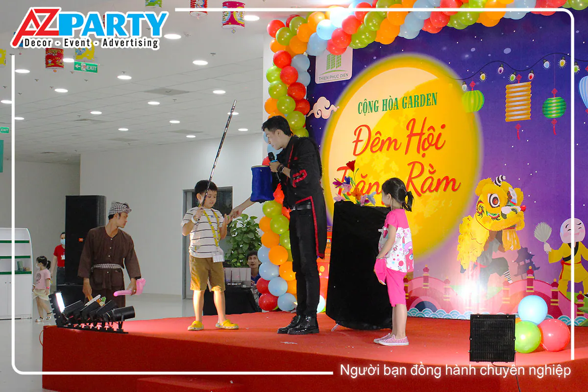 Hai bé thiếu nhi được mời lên sân khấu hỗ trợ ảo thuật gia trong một màn ảo thuật kỳ thú.