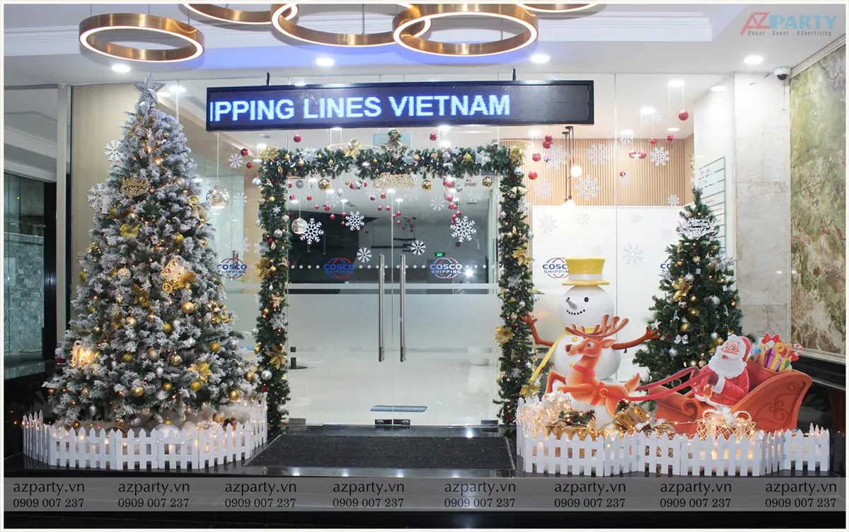 Trang trí tiểu cảnh Noel trước cửa văn phòng COSCO SHIPPING LINES VIETNAM với cây thông phủ tuyết, người tuyết và cỗ xe tuần lộc.