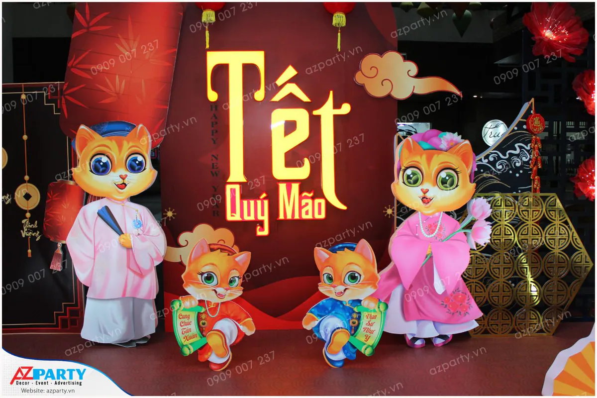 Cận cảnh mô hình gia đình mèo Quý Mão mặc áo dài truyền thống nâng câu đối chúc mừng năm mới mộc mạc và đáng yêu