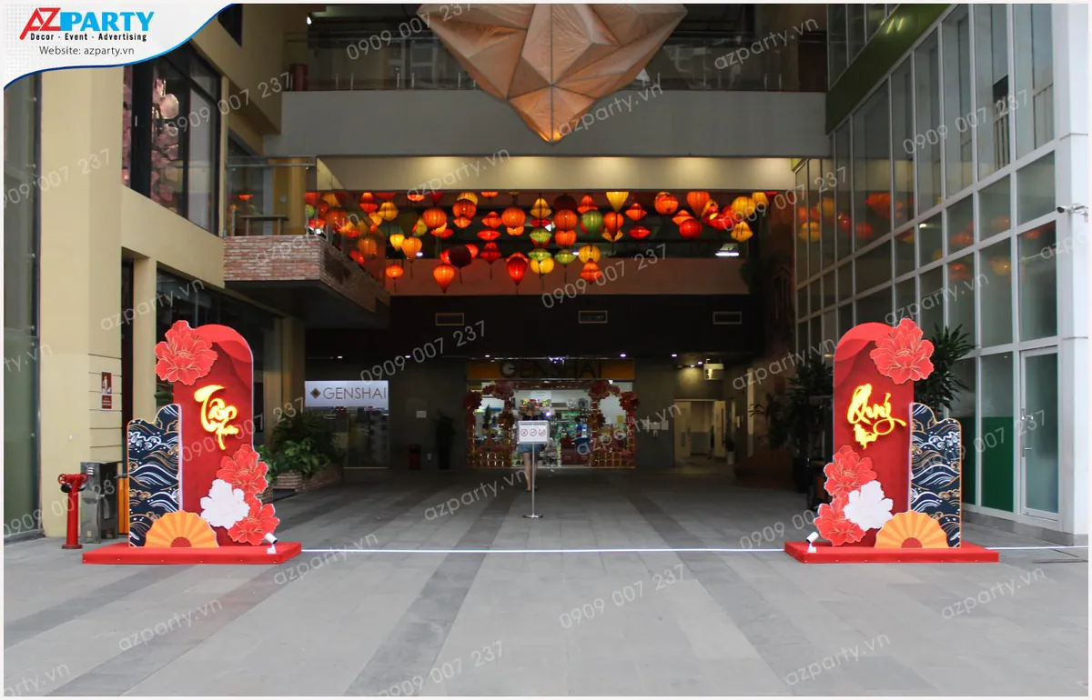 Lối vào trung tâm thương mại Faifo Lane được trang trí bằng hai trụ cổng chào Tết màu đỏ nổi bật kết hợp hoa mẫu đơn và họa tiết sóng biển